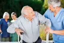 Male caregiver helping senior man